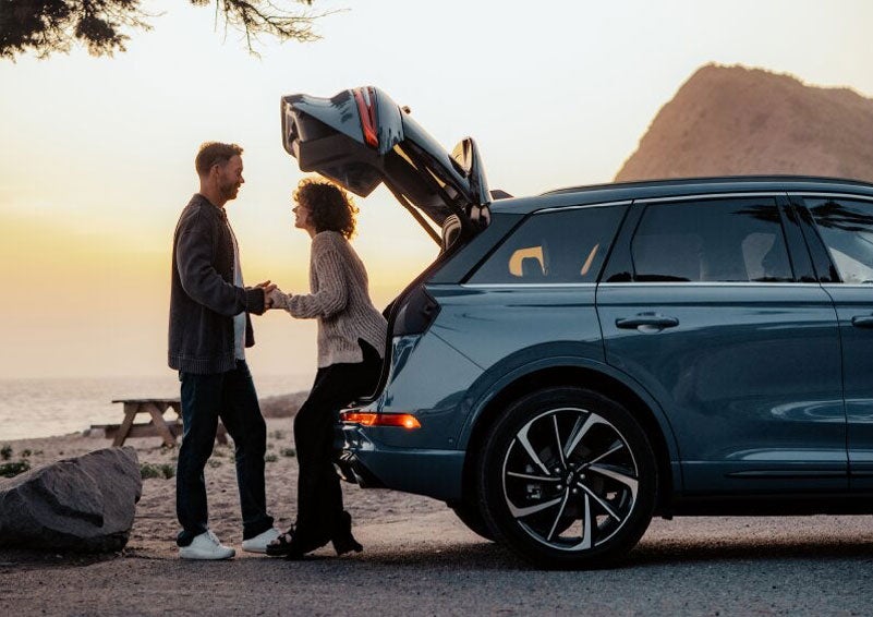A couple share a moment together outside a 2025 Lincoln Corsair® SUV near the open liftgate. | Doggett Lincoln of Beaumont in Beaumont TX