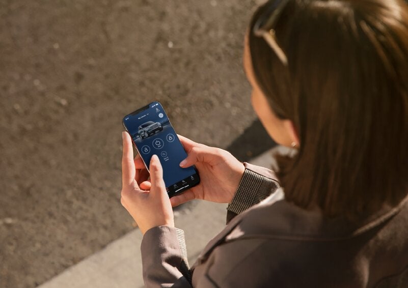 A person is shown interacting with a smartphone to connect to a Lincoln vehicle via the Lincoln Way® App. | Doggett Lincoln of Beaumont in Beaumont TX