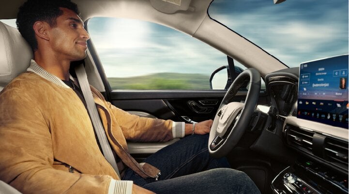 A person is shown using Lincoln BlueCruise hands-free highway driving technology on a divided highway called a Hands-Free Blue Zone. | Doggett Lincoln of Beaumont in Beaumont TX