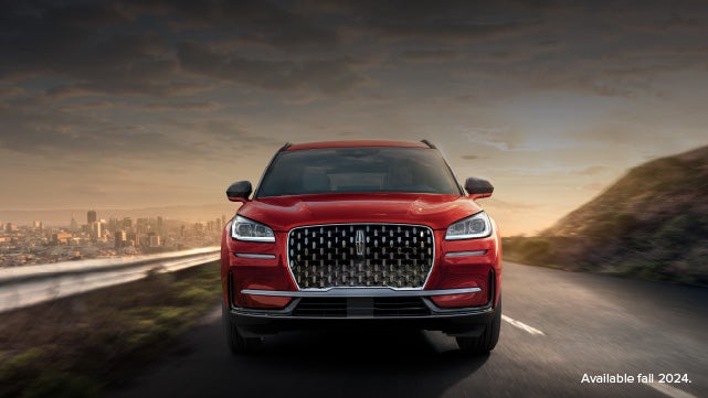 A 2025 red Lincoln Corsair® SUV is being driven down a road at sunset. | Doggett Lincoln of Beaumont in Beaumont TX