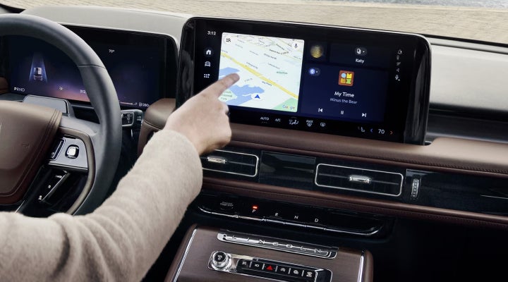 A person is tapping the center display touchscreen of a 2026 Lincoln Aviator® SUV. | Doggett Lincoln of Beaumont in Beaumont TX