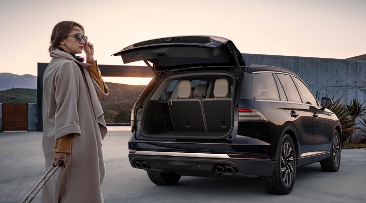 A woman approaches a 2026 Lincoln Aviator® SUV with its rear liftgate open. | Doggett Lincoln of Beaumont in Beaumont TX